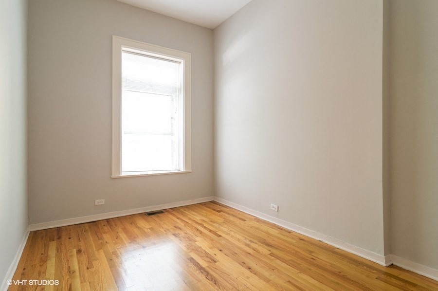 an empty room with wooden floors and a window