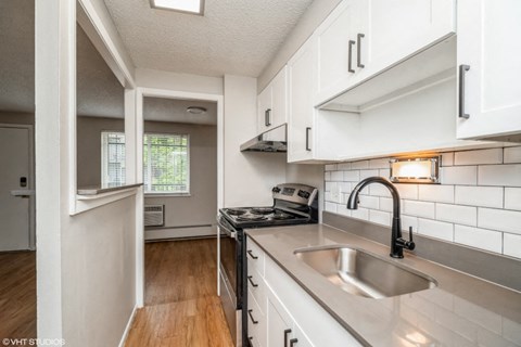a kitchen with white cabinets and a sink
