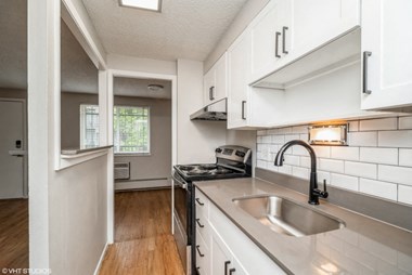Renovated kitchen with granite countertops and white cabinetry