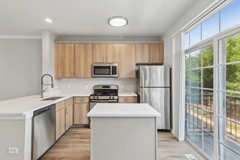 A modern kitchen with wooden cabinets and stainless steel appliances.