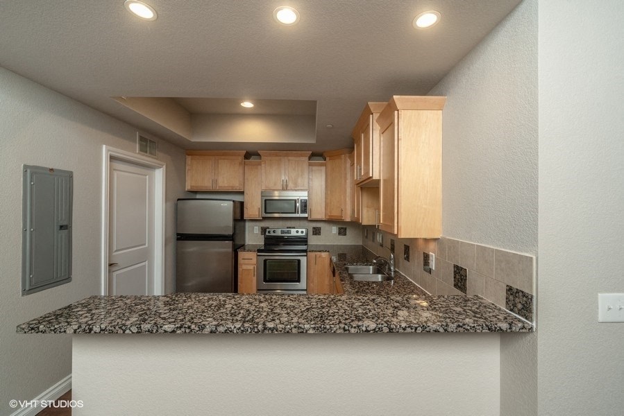 Rich wood cabinets and a glass top stove