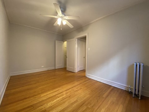 a living room with a wood floor and a ceiling fan