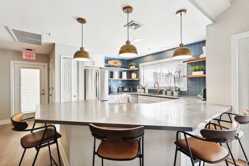 A modern kitchen with a large island and chairs.