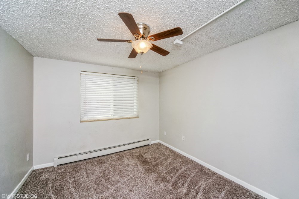 Bedroom with a ceiling fan and plush carpeting