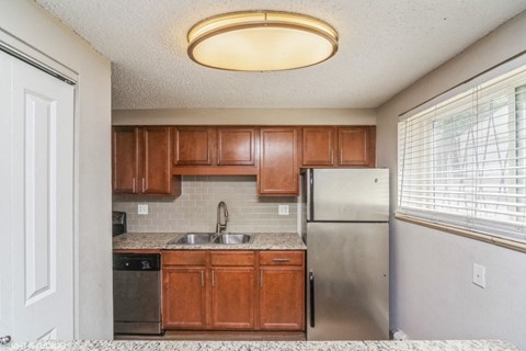 a kitchen with wooden cabinets and a stainless steel refrigerator