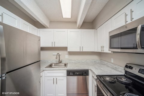 a kitchen with stainless steel appliances and white cabinets
