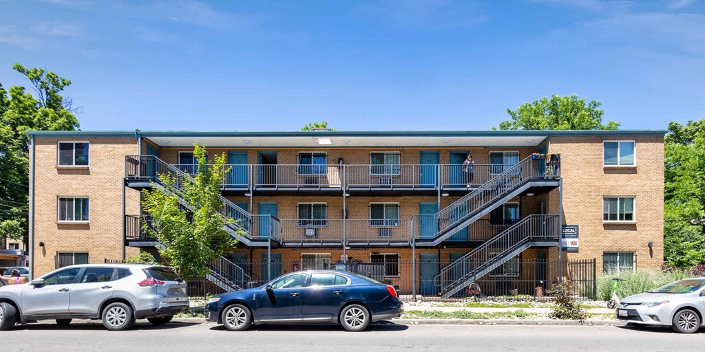 an apartment building with cars parked in front