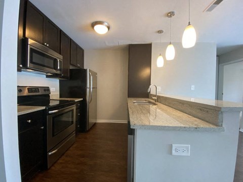 a kitchen with stainless steel appliances and a marble counter top