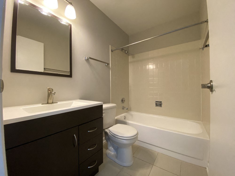 Bathroom with vanity storage and a full tub