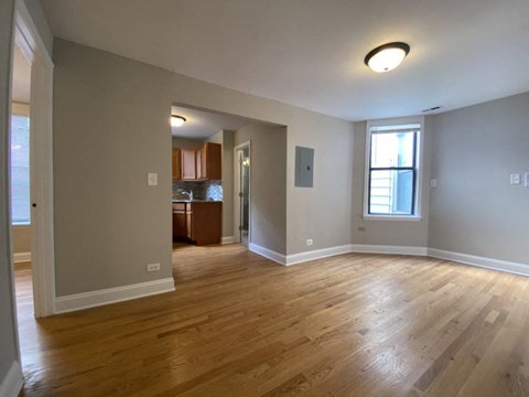 a living room with a hard wood floor and a window