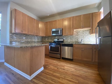 a kitchen with wooden cabinets and stainless steel appliances