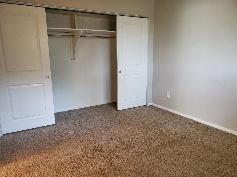 Bedroom with plush carpeting and a large closet