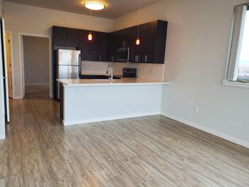 A kitchen with a white countertop and wooden flooring.