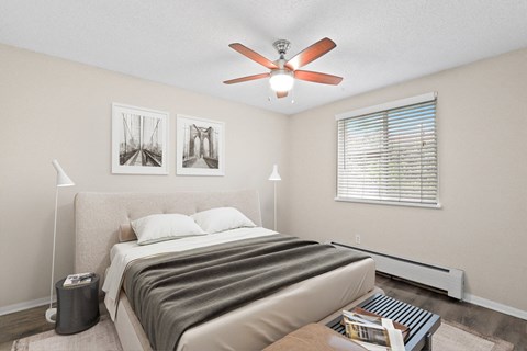 Relax in a light-filled bedroom with neutral tones, cozy textures, and a modern ceiling fan at 1303 Columbine in Denver, CO