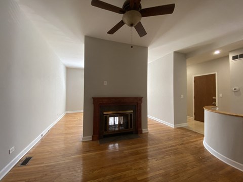 a living room with a fireplace and a ceiling fan