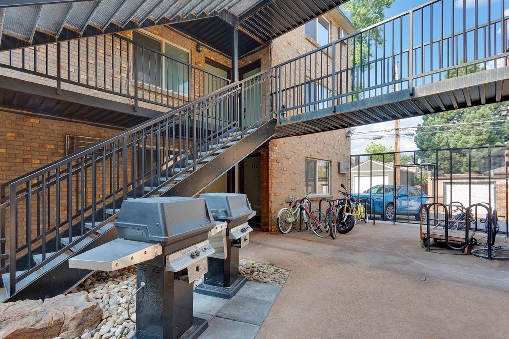 A black metal staircase with a glass balustrade leads to a balcony at 23–33 Pearl St in Denver, CO
