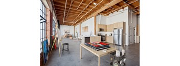 A room with a wooden ceiling and a table with a book on it.