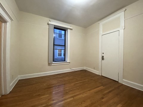 A room with a wooden floor and a window.