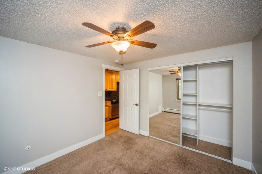 Bedroom with a ceiling fan and a large closet at 23–33 Pearl St in Denver, CO