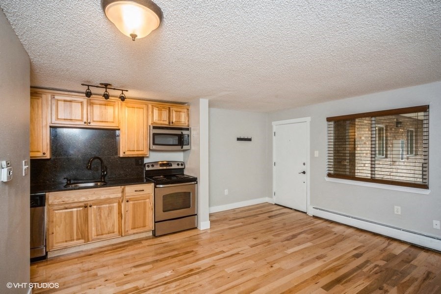 Open living area with rich wood flooring at 23–33 Pearl St in Denver, CO