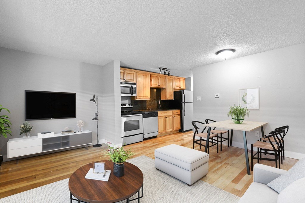 A modern living room with a wooden floor and white walls at 23–33 Pearl St in Denver, CO