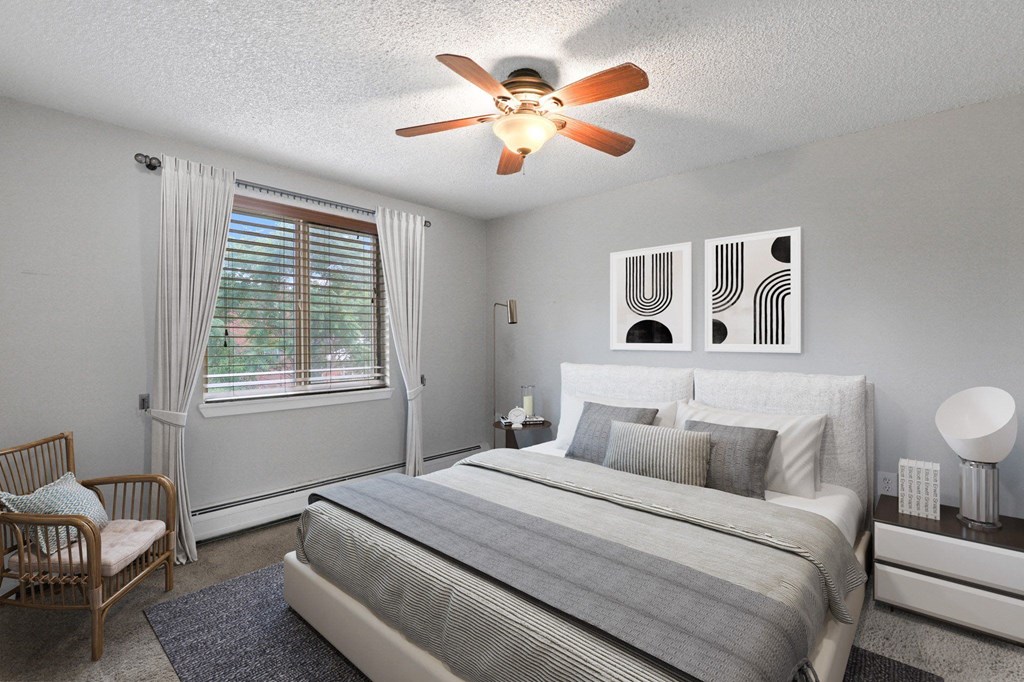 A bedroom with a bed, nightstand, and chair at 23–33 Pearl St in Denver, CO