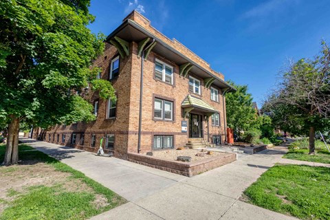 A red brick building with a green roof and a white door 1170 N Logan St in Denver, CO