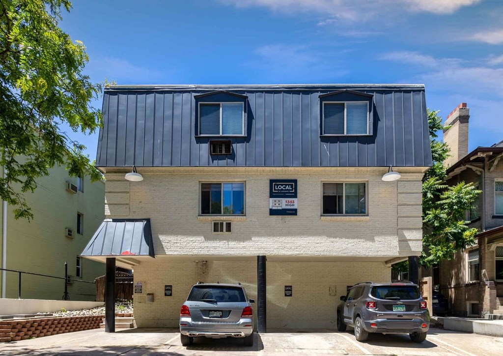 a building with a blue roof and two cars parked in front of it