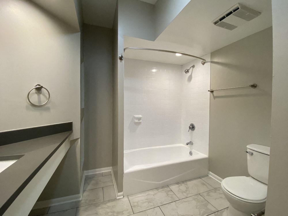 Bathroom with a full tub with tiled surround