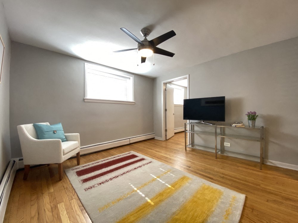 Living room with hardwood flooring and a ceiling fan
