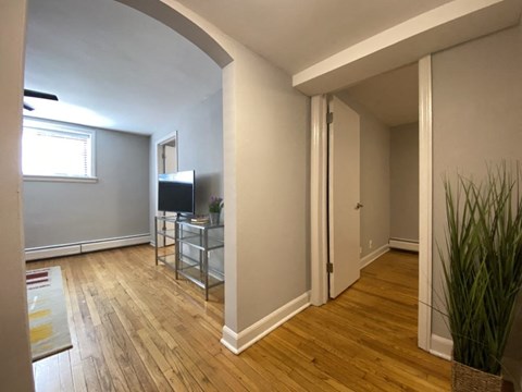 a living room with a tv and a wooden floor