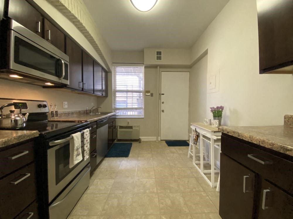 Kitchen with rich wood cabinetry - 2 Bedroom A