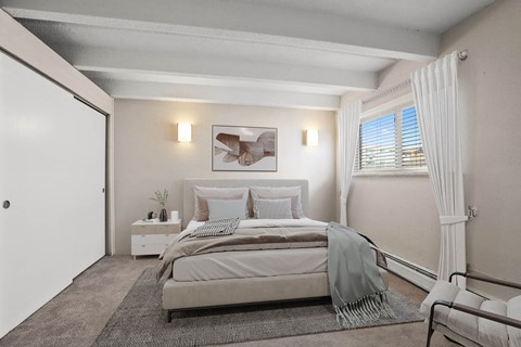 Tranquil and inviting, this spacious bedroom features soft lighting, neutral tones, and serene views at 1140–1160 S Bellaire St in Denver, CO
