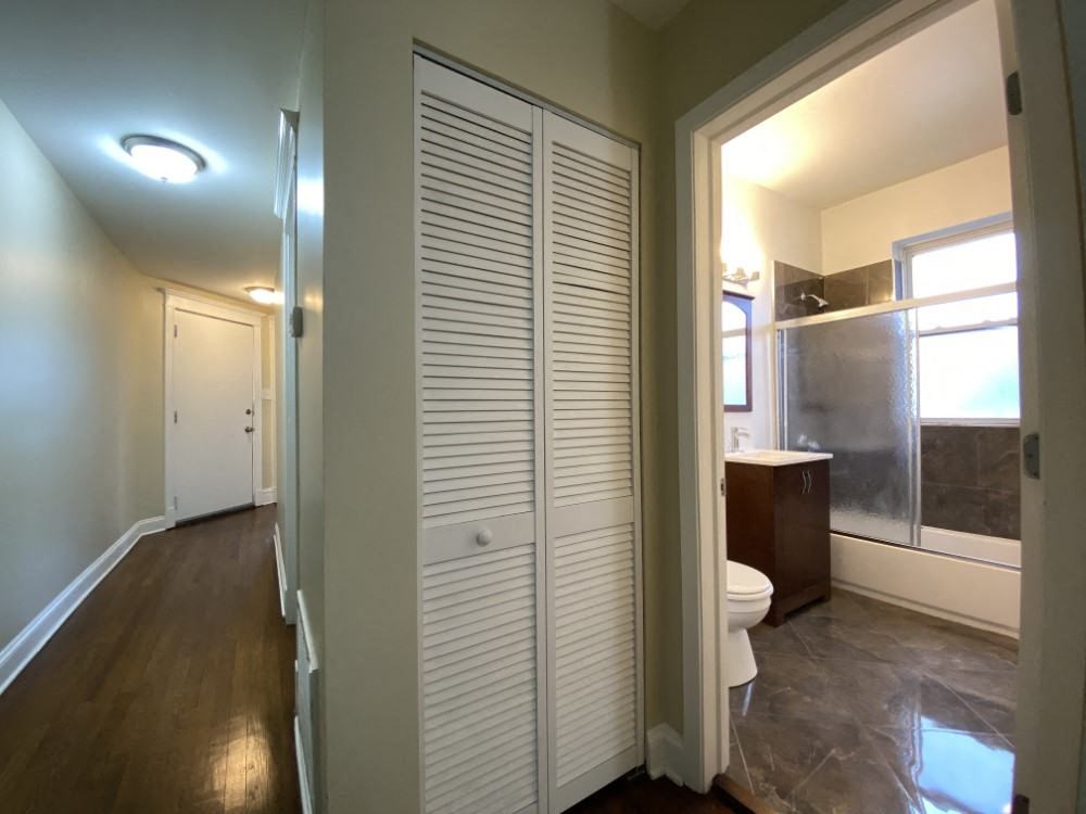 A white closet with a toilet in the bathroom.