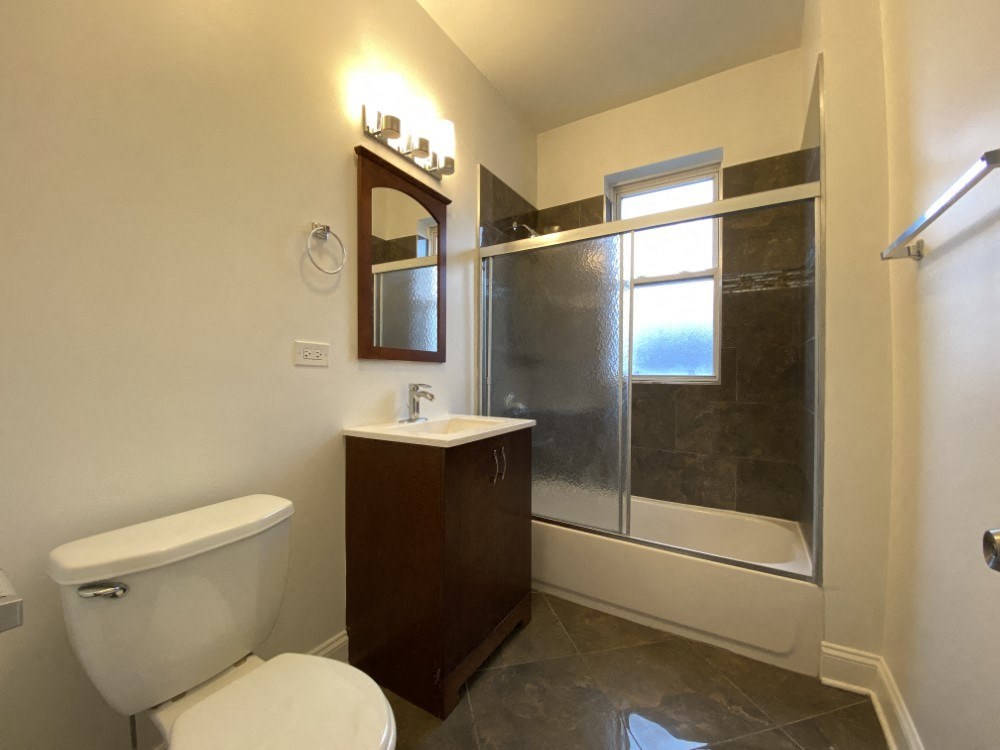A white toilet sits next to a sink in a bathroom.