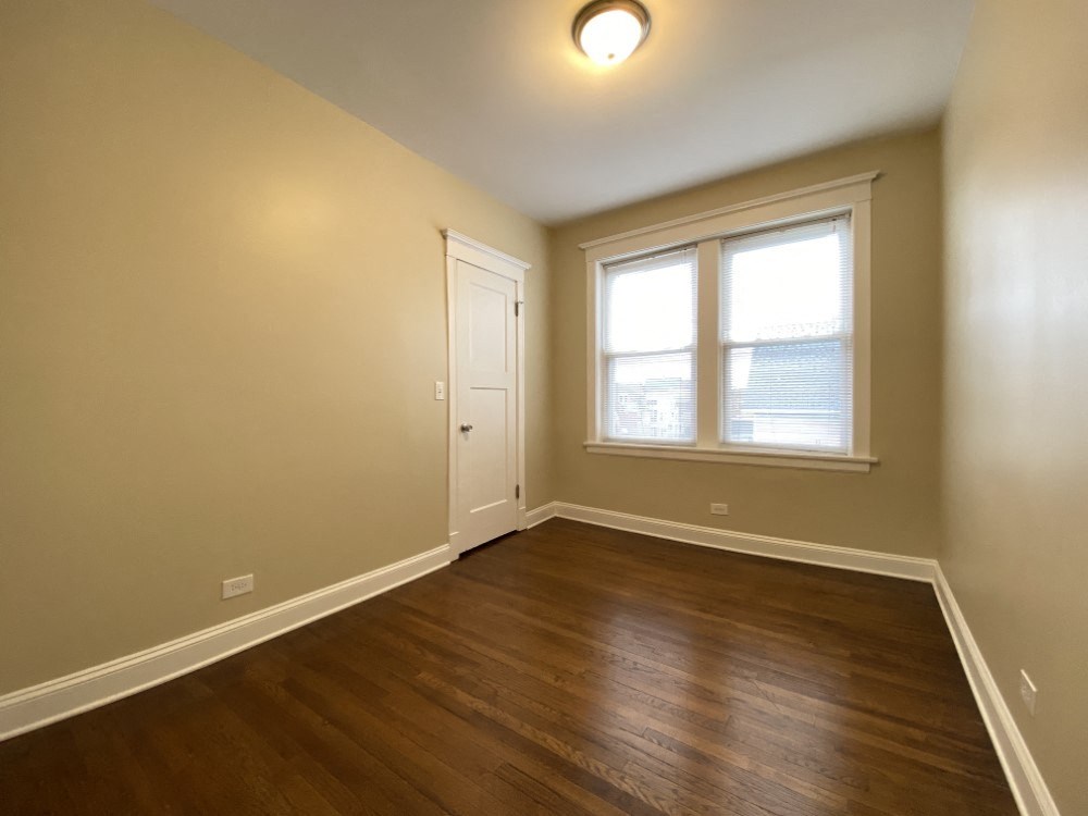 A room with a wooden floor and a window.