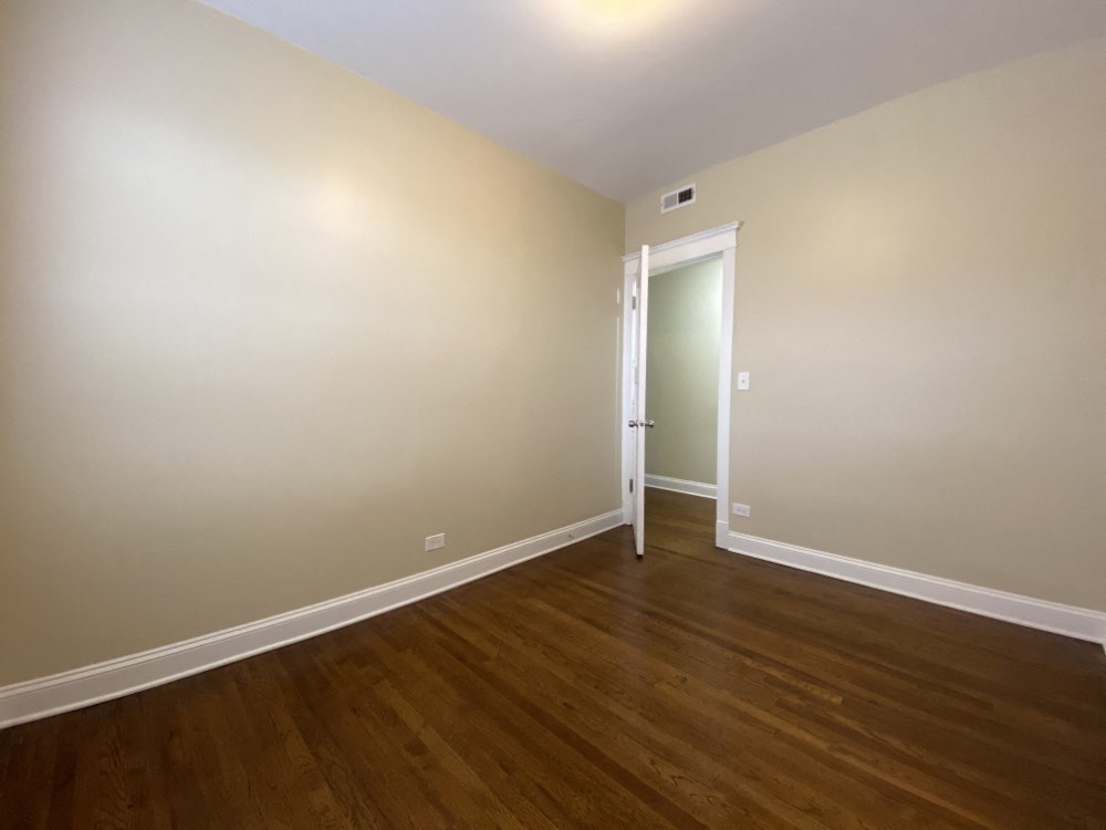 A room with a wooden floor and a white door.