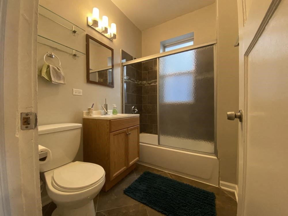 A bathroom with a toilet, sink, and shower.