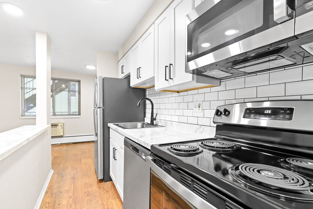 a kitchen with stainless steel appliances and white cabinets
