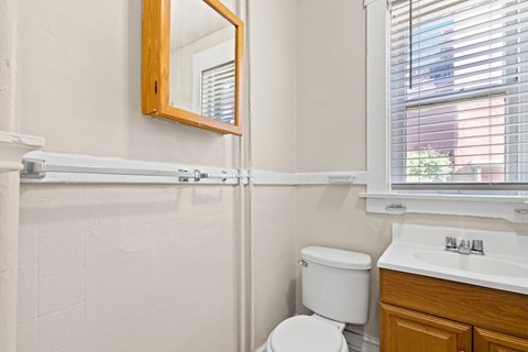 A white toilet sits next to a sink in a bathroom 1170 N Logan St in Denver, CO
