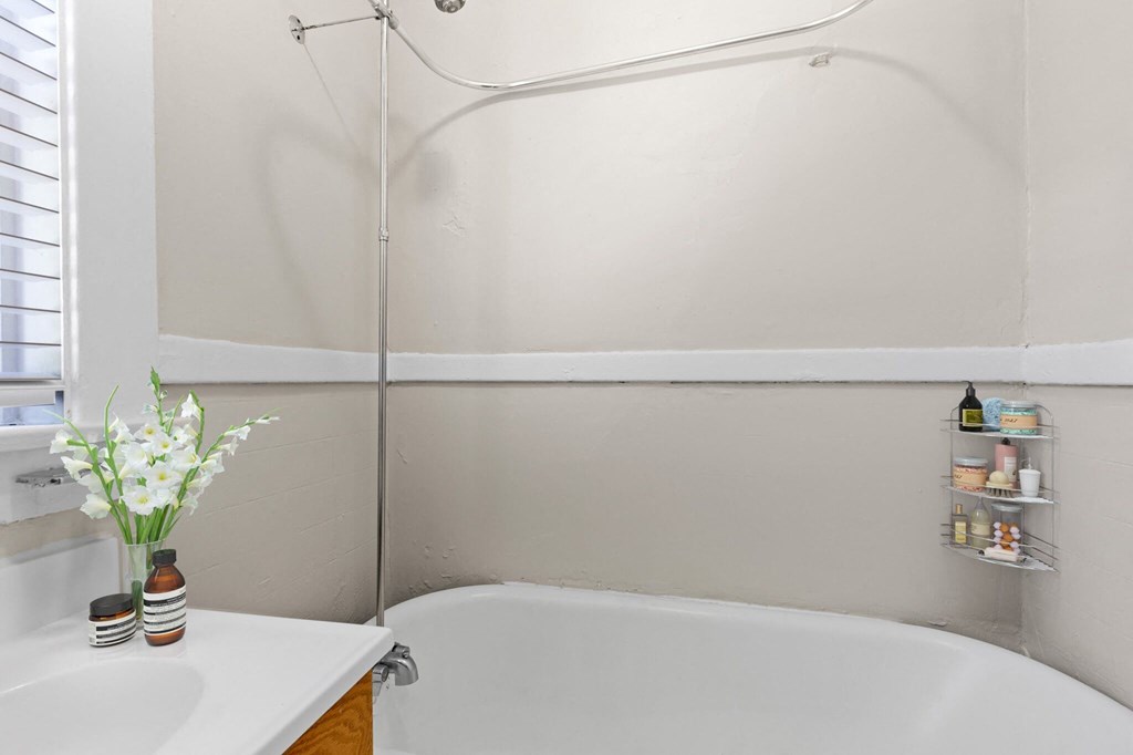 a bathroom with a tub and a sink and a window