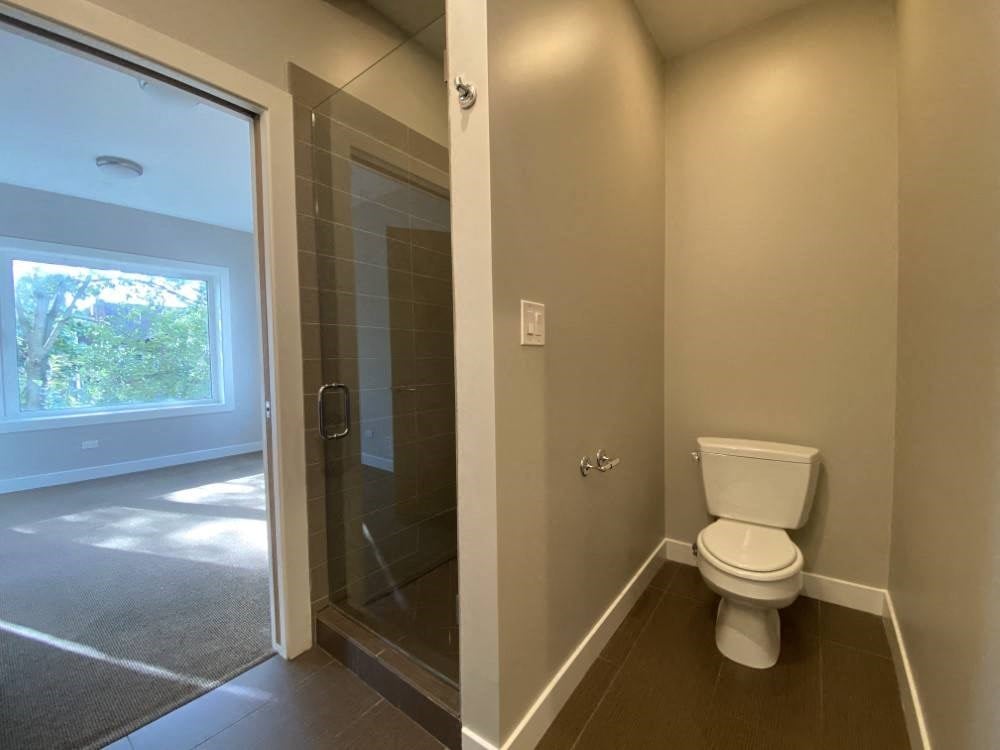 Shower with glass door in bathroom off the bedroom