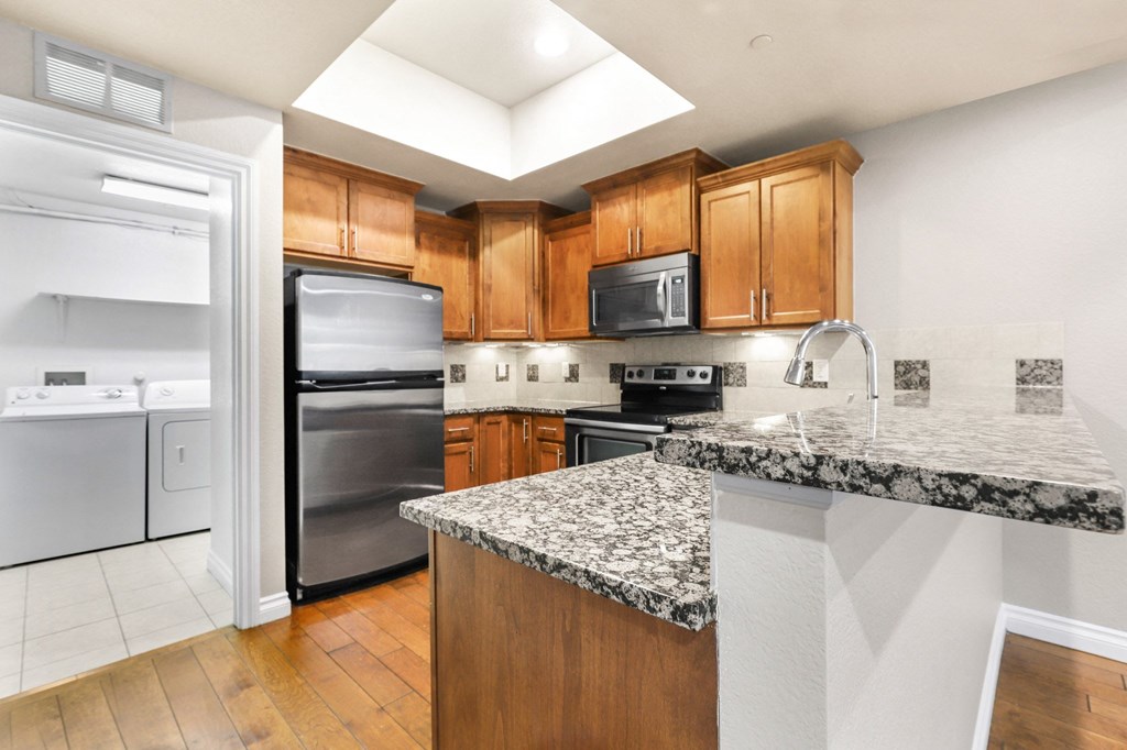 a kitchen with granite counter tops and stainless steel appliances