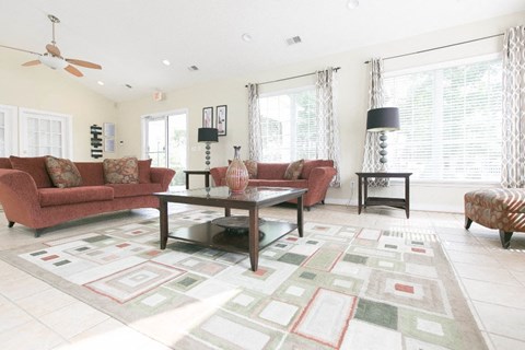 A living room with a red couch and a glass coffee table.