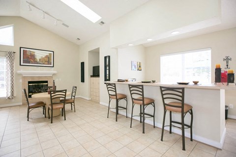A kitchen with a dining table and chairs.