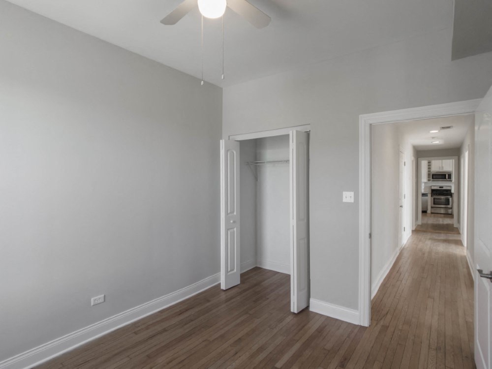 Bedroom one with ample closet space and a ceiling fan