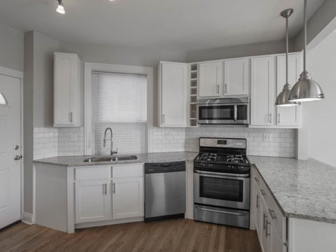 a kitchen with white cabinets and stainless steel appliances