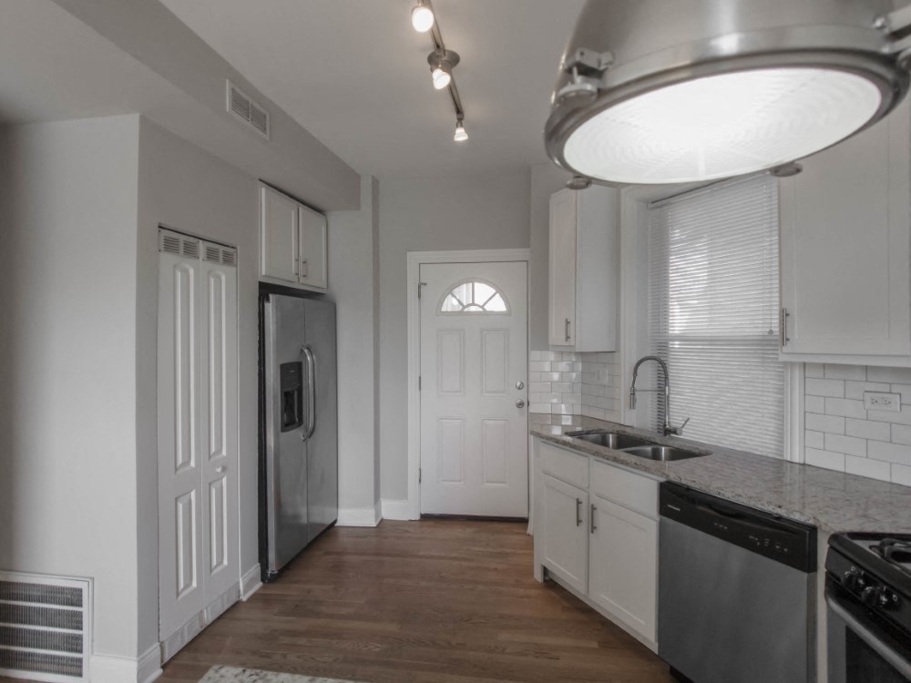 Open kitchen with brushed nickel pendant lighting