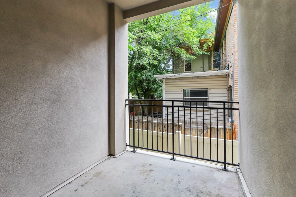the patio of a house with a fence and a balcony
