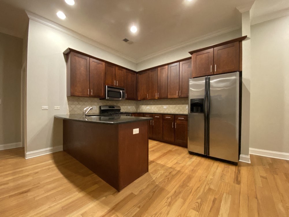 Kitchen with stainless steel appliances and tiled backsplash - 3 Bedroom